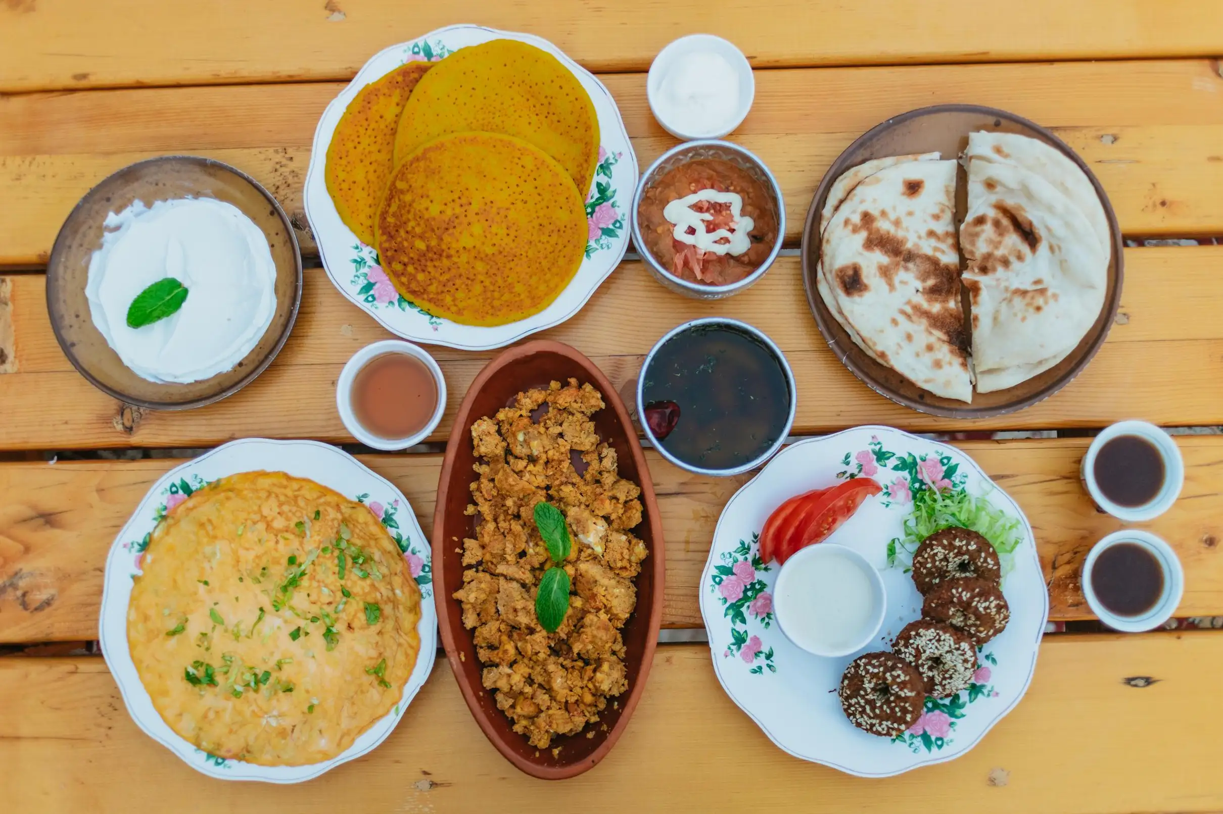 Delicious Middle Eastern breakfast dishes arranged on a wooden table, top-down view